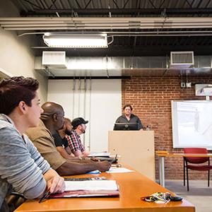 Male students focusing on teacher at front of room